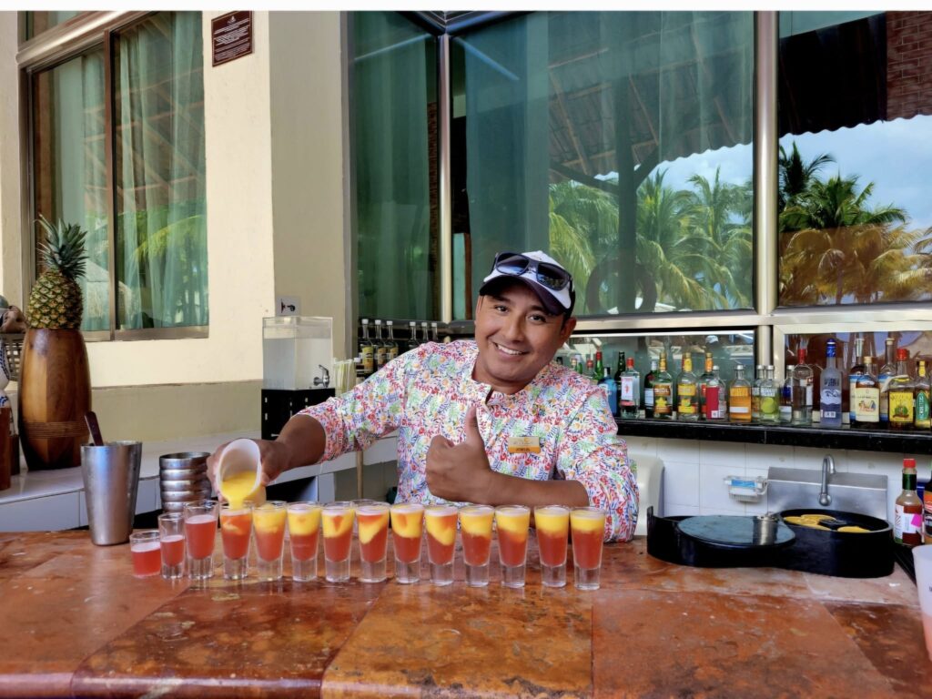 Bartender making colorful and delicious cocktails at El Dorado Maroma adult-only resort