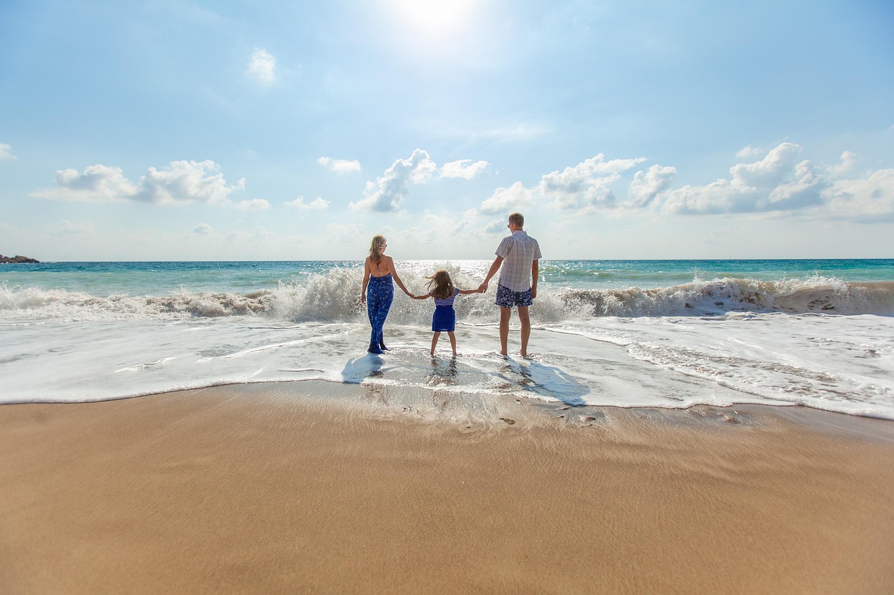 Family holding hands at the shoreline during a spring break beach vacation