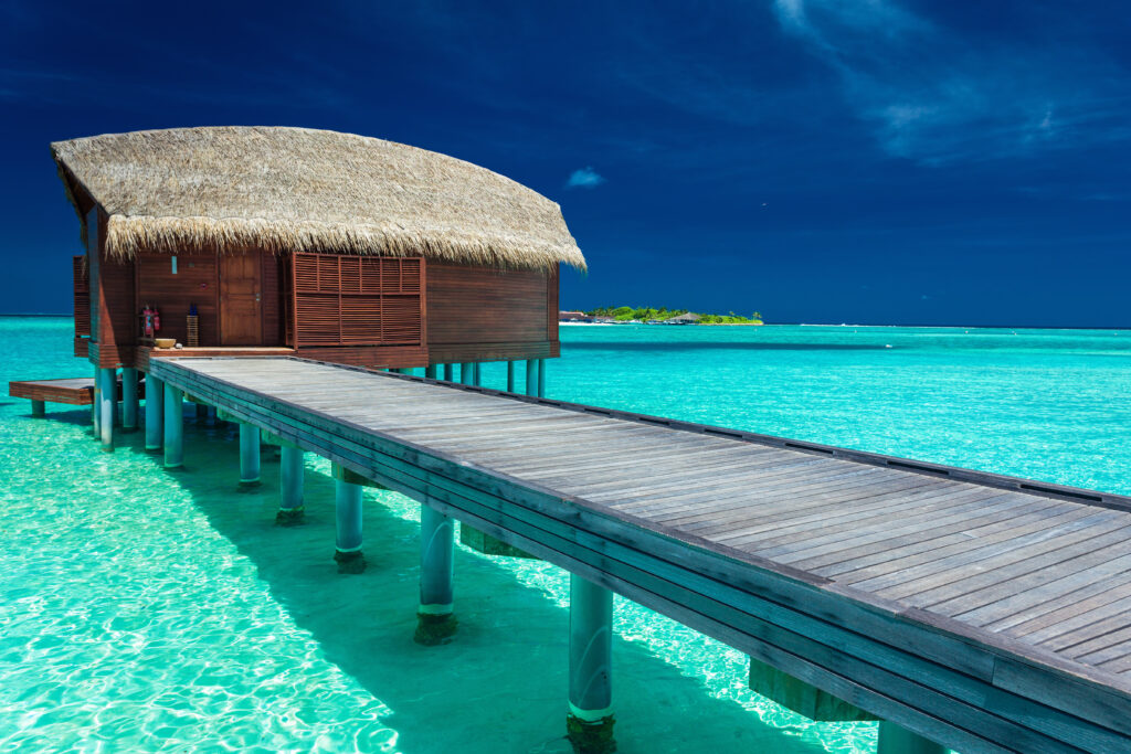 Overwater bungalows above a turquoise Maldives lagoon, a luxury island honeymoon package in the Indian Ocean