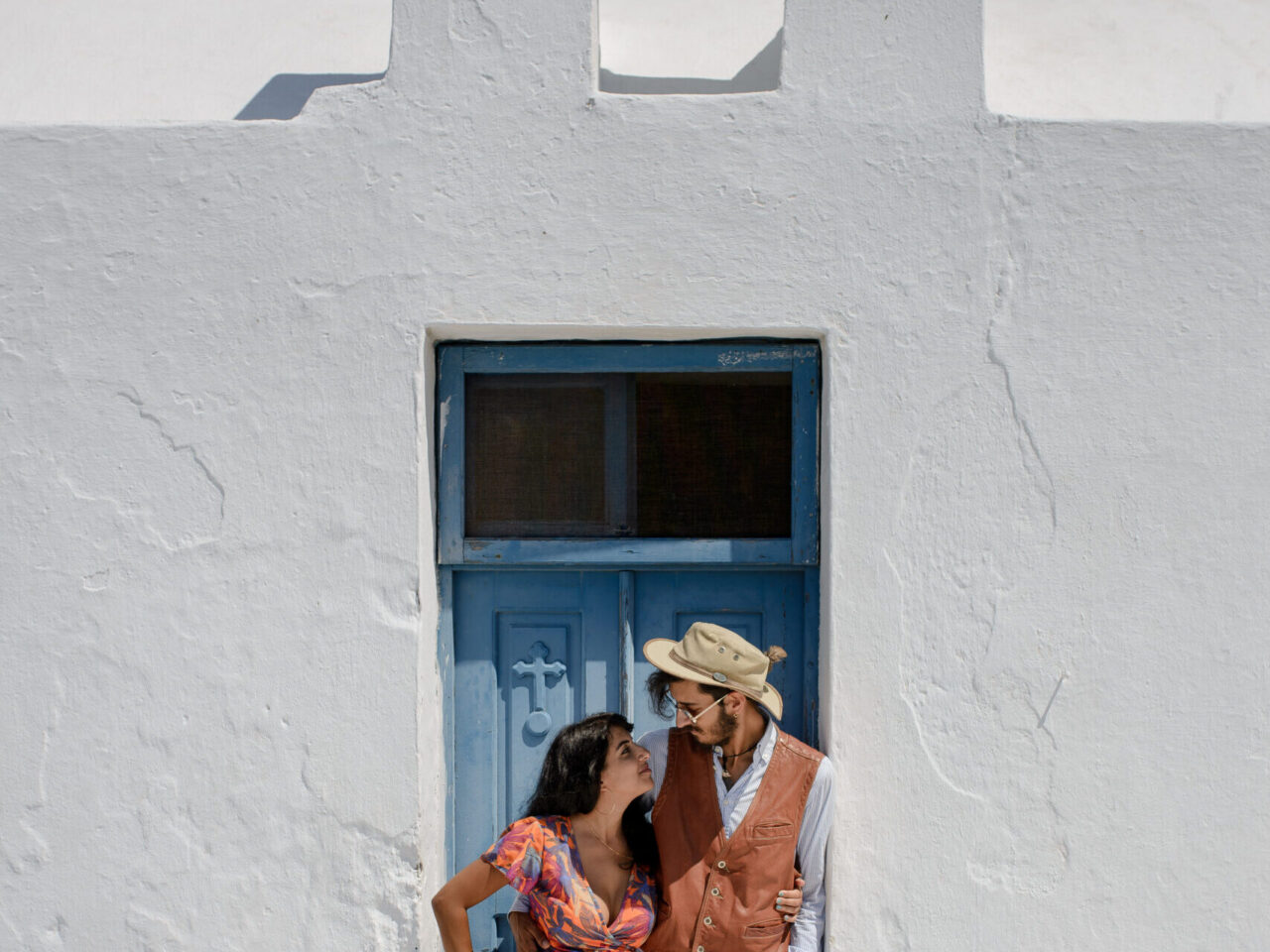 Young couple looking out over the whitewashed landscape of a Greek island in the Cyclades