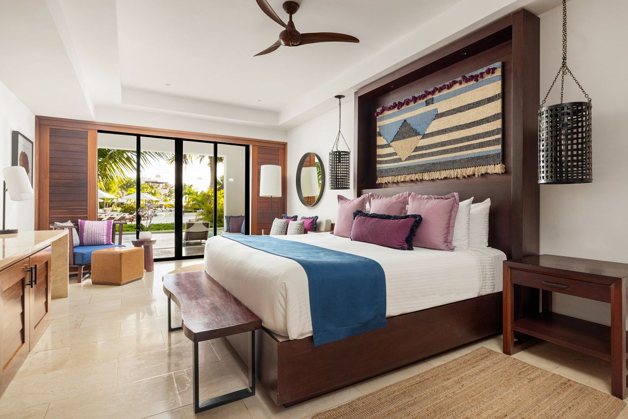 Junior Suite Swim Out at Secrets Cap Cana with a ground floor terrace opening onto the swim out channel and the pool deck beyond