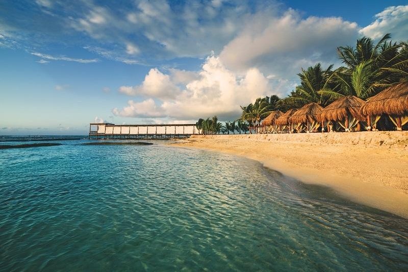 Beach and pier at golden hour at El Dorado Seaside Palms in the Riviera Maya