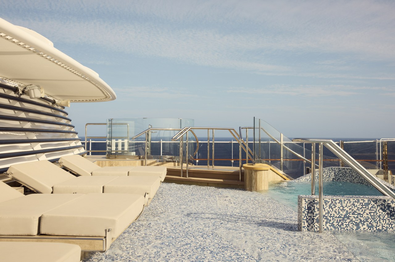 Sun loungers and whirlpool on the upper deck of an Explora Journeys luxury small ship